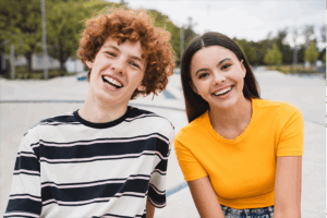Teenage boy and girl smiling together outdoors
