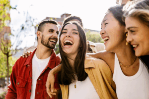 Group of four friends laughing together outdoors